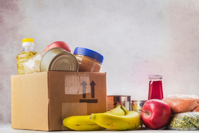 Caja con manzanas, bananos y otros víveres