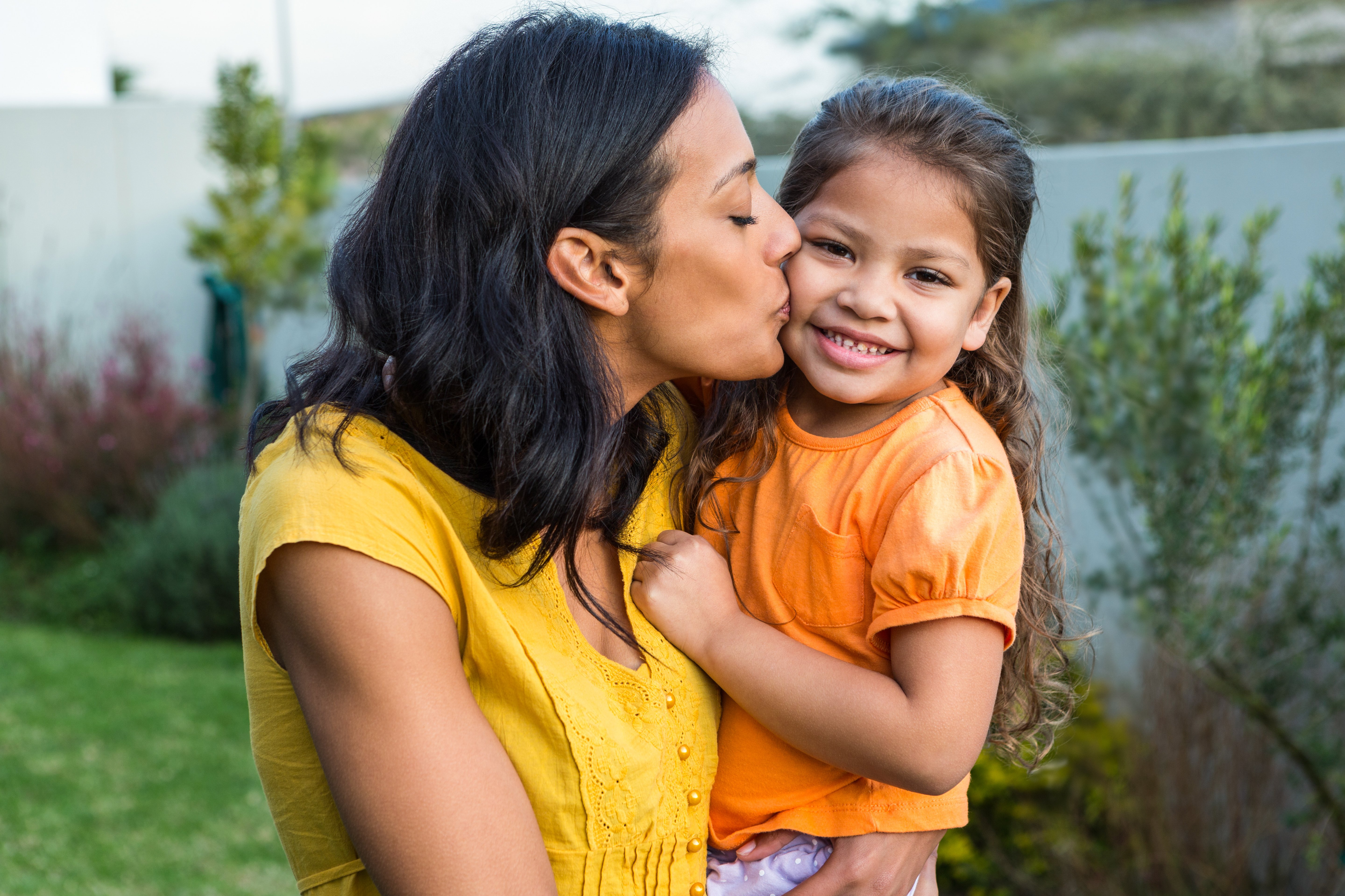 lovely-mother-kissing-her-daughters-cheek