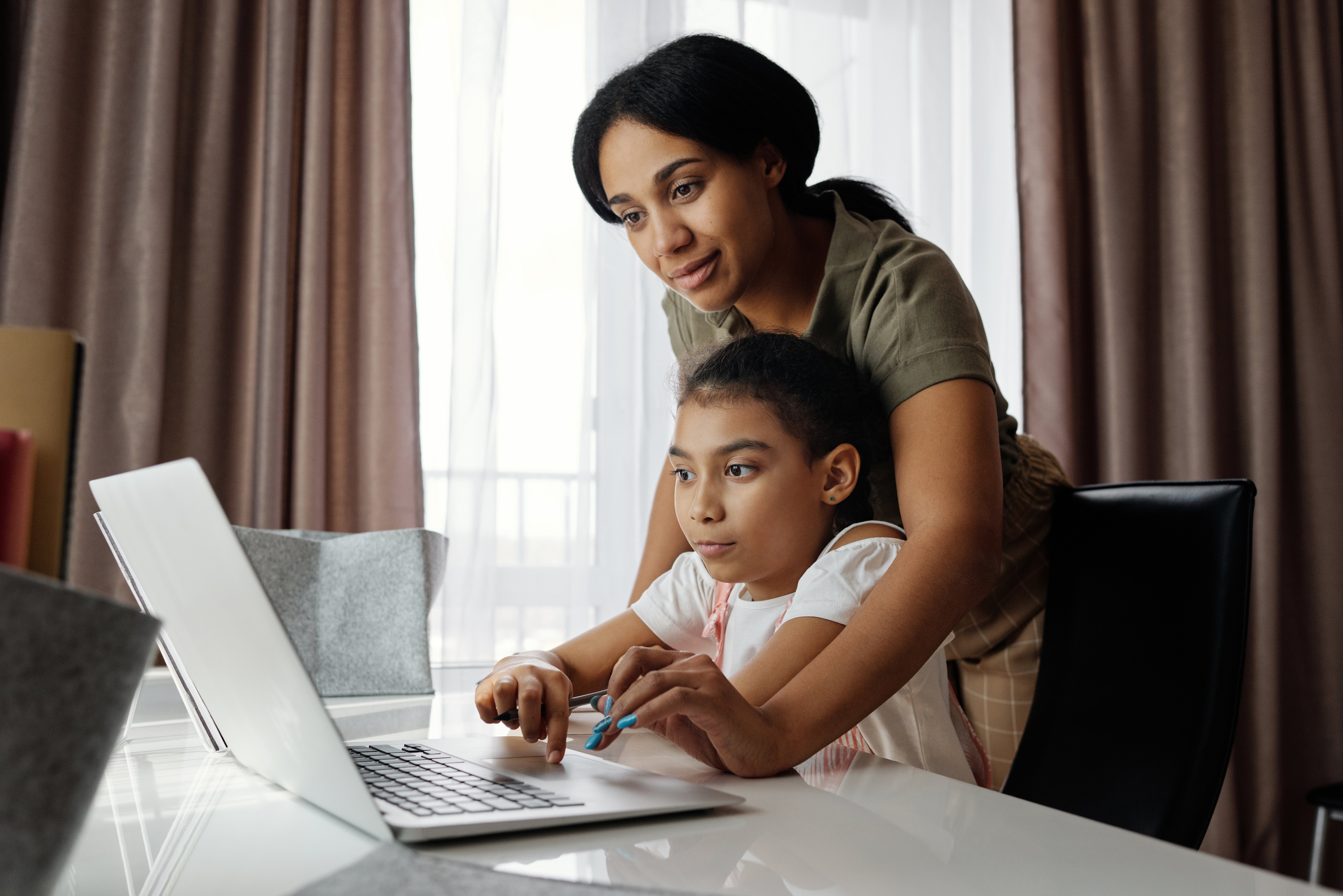 mother-helping-her-daughter-use-a-laptop-4260325
